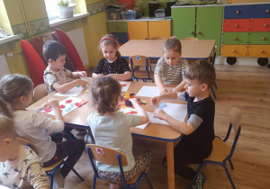 Dzieci układają skrawki bibuły.